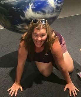 Smiling Karen on hands and knees, having fun with a big exercise ball